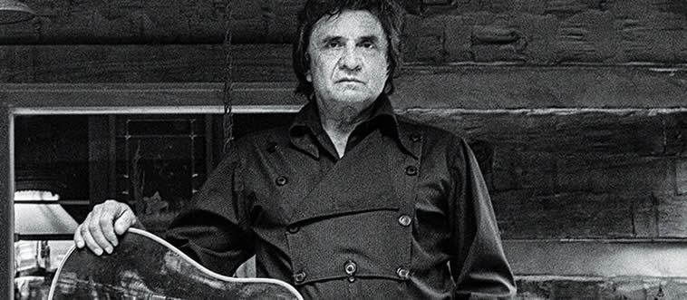 Which iconic performer dressed in all-black and recorded legendary live sets inside Folsom Prison and San Quentin?